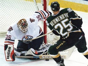 Edmonton Oilers goalie Tommy Salo makes a save as Dallas Stars captain Joe Nieuwendyk closes in during Game 4 of their Western Conference quarterfinal playoff series on April 27, 1999, at Edmonton's Skyreach Centre.