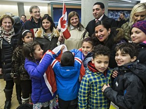 People are on hand to greet refugees from Syria at the Edmonton International Airport in Edmonton, Alta., on Monday, Dec. 28, 2015. File photo.