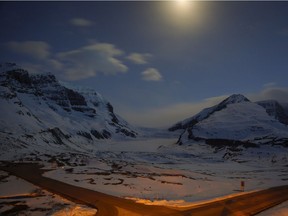 The Athabasca Glacier, centre, part of the Columbia Icefields in Jasper National Park, Alta., is seen in moonlight during a long exposure Wednesday, May 7, 2014. Parks Canada often promotes the Icefields Parkway between Jasper and Banff as "one of the most scenic drives in the world," but a plan to build a bike path along the route has hit its fair share of bumps in the road.
