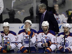 Edmonton Oilers coach Todd McLellan, top, and his players watch from the bench in the closing minutes of a 7-0 loss to the San Jose Sharks in Game 4 of a first-round NHL hockey playoff series on April 18, 2017, in San Jose, Calif.