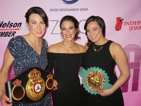 World featherweight boxing champion Jelena Mrdjenovich,
centre, was hard to recognize out of the ring when she showed up at the Art Gallery of Alberta with her title belts and sisters Aleksa, left, and Milica to host the premiere of a documentary about her boxing career.