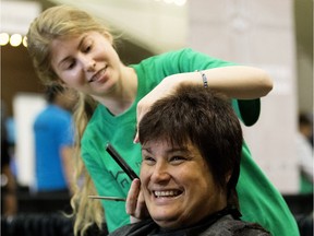 Theresa Baron smiles as she receives a haircut from MC College volunteer Alicia Molzahn during the 18th annual Homeless Connect event at the Shaw Conference Centre, in Edmonton Sunday May 7, 2017. Approximately 1,600 people were expected to take part in the event which provided health care, dental care, counselling, legal services, employment information, and housing resources.