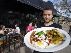Liam Woolman holds an order of huevos rancheros at The Next Act Pub, 8224 104 St., in Edmonton Saturday May 6, 2017.