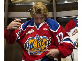 Jake Neighbours puts on an Edmonton Oil Kings jersey while being introduced to the media at Rogers Place, in Edmonton Thursday May 25, 2017.