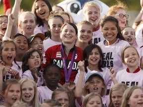 Young female soccer players take a giant selfie photo with Team Canada's Diana Matheson, centre,  during halftime at a NASL game between FC Edmonton and Indy Eleven at Clarke Stadium in Edmonton on May 27, 2017.