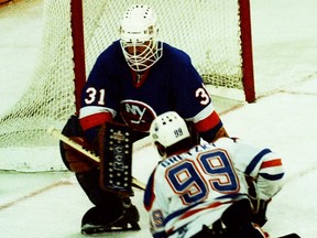 New York Islanders goalie Billy Smith waits for a shot by Edmonton Oilers star Wayne Gretzky on May 17, 1984, during Game 4 of the Stanley Cup Final at Northlands Coliseum.