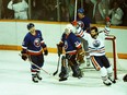 From left, New York Islanders captain Denis Potvin grimaces beside goalie Billy Smith as Edmonton Oilers forward Dave Semenko celebrates a goal on May 17, 1984, during Game 4 of the Stanley Cup Final at Northlands Coliseum.