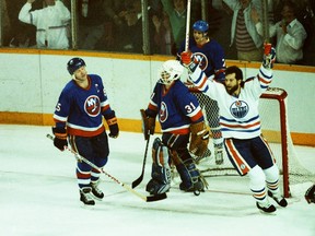 From left, New York Islanders captain Denis Potvin grimaces beside goalie Billy Smith as Edmonton Oilers forward Dave Semenko celebrates a goal on May 17, 1984, during Game 4 of the Stanley Cup Final at Northlands Coliseum.