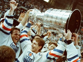 Edmonton Oilers captain Wayne Gretzky holds the Stanley Cup alongside teammates, including Kent Nilsson, left, after the Oilers beat the Philadelphia Flyers 3-1 in Game 7 of the Stanley Cup Final on May 31, 1987, at Edmonton's Northlands Coliseum.