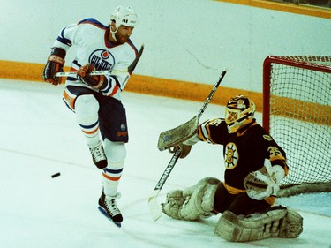 Edmonton Oilers forward Glenn Anderson jumps to avoid getting hit by the puck as Boston Bruins goalie looks to make the save on May 26, 1988, at Northlands Coliseum in Game 4 of the Stanley Cup final.