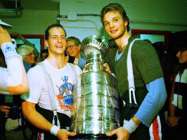 Edmonton Oilers forwards Norm Lacombe, left, and Mike Krushelnyski hold the Stanley Cup in the team's dressing room on May 26, 1988, at Northlands Coliseum after they beat the Boston Bruins 6-3 in Game 4 of the final to win the league title.