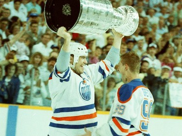 Edmonton Oilers centre Mark Messier, left, hoists the Stanley Cup after captain Wayne Gretzky passes it to him on May 26, 1988. The Oilers beat the Boston Bruins 6-3 in Game 4 of the Stanley Cup final at Northlands Coliseum to win the league title.