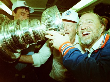 Edmonton Oilers owner Peter Pocklington, right, smiles as he drinks from the Stanley Cup on May 26, 1988, at Northlands Coliseum. The Oilers beat the Boston Bruins 6-3 in Game 4 of the Stanley Cup final to win the league title.