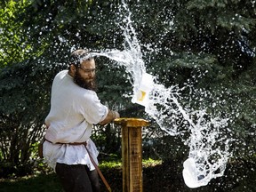 Squire Garrett (Garrett Magnan) destroys a jug of water with a longsword during a medieval weapons demonstration during the Knights of the Northern Realm's seventh annual Medieval May at King Edward Park Community League in Edmonton on Saturday, May 27, 2017. (Codie McLachlan/Postmedia)