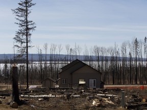 A rebuilt home and cut down fire damaged trees from the 2016 wildfires are seen in the Lone Pine Estates near the intersection of Hopegood Drive and Gregoire Drive in Anzac, near Fort McMurray on Sunday, April 9, 2017.