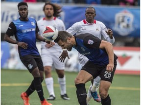 Adam Straith of FC Edmonton, heads the ball out of the 18 years box against  the San Francisco Deltas at Clark Field in Edmonton on May 14, 2017.