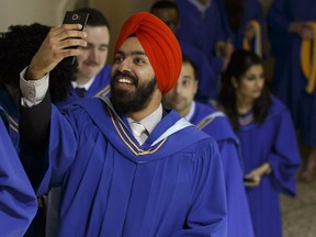 Jagrit Bajwa, a bachelor of business administration in accounting graduate and Punjabi rapper, takes a photo during Northern Alberta Institute of Technology's convocation held at the Northern Jubilee Auditorium in Edmonton on Friday, May 5, 2017.