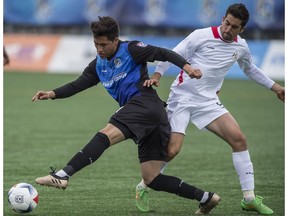 Dustin Corea of FC Edmonton, is slowed by Tyler Gibson of the San Francisco Deltas at Clark Field in Edmonton on Sunday, May 14, 2017. (Shaughn Butts)