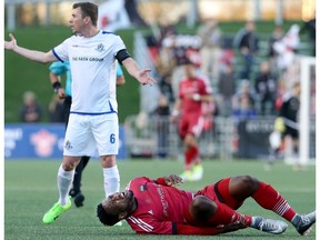 Edmonton's Nick Ledgerwood tries to explain lack of fault to the ref as Ottawa's Eddie Edward writhes in pain after they tangled on the field in the first half. The Ottawa Fury FC (red) met up with FC Edmonton during the first leg of the Canadian Championship at TD Place in Ottawa Wednesday, May 3, 2017.