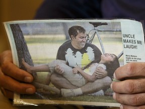 Elias Malkum and his wife Milena Duran hold the photo of Malkum's brother Leonardo Duran Ibanez while speaking about his loss at their home in Edmonton, Alberta on Wednesday, November 16, 2016. A GoFundMe page has been setup to help Malkum send his brother's body home to Columbia for a funeral with family.