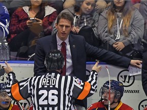 Coach Kris Knoblauch of the Erie Otters gets an explanation of a call from a referee during OHL action on Nov. 27, 2015 at the Hershey Centre in Mississauga, Ont.