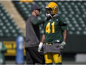 Head coach Jason Maas taps Odell Willis on the shoulder during the first day of training camp for the Eskimos on Sunday May 28, 2017, in Edmonton.