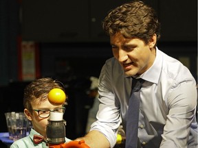 Prime Minister Justin Trudeau (right) met with families at the Telus World of Science in Edmonton on Saturday May 20, 2017 to bring attention to the Canada Child Benefit. In this photo he participates in a science experiment with Adrien Mills (7-years-old). (PHOTO BY LARRY WONG/POSTMEDIA)