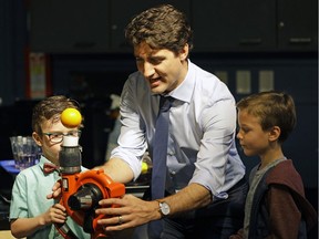 Prime Minister Justin Trudeau (middle) participates in a science experiment at the Telus World of Science in Edmonton on Saturday May 20, 2017 where Trudeau met with families to bring attention to the Canada Child Benefit.