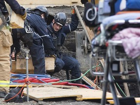 Emergency crews work at the scene of a trench collapse with a trapped victim, at a home under construction along 123 Street near 107 Avenue, in Edmonton on Tuesday, April 28, 2015.