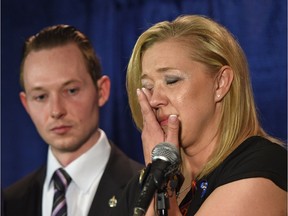 Shelly MacInnis-Wynn, the widow of Const. David Wynn, wipes tears as she responds to the Liberal's defeat of Bill S-217 known as Wynn's Law at committee during a news conference as MP Michael Cooper looks on in St. Albert on May 12, 2017.