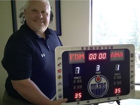 Will Nault, co-founder of Fantasy Scoreboards Inc., poses with one of his scoreboards, displaying the Edmonton Oilers' 7-1 victory over the Anaheim Ducks in Game 6 of the Western Conference semifinal.