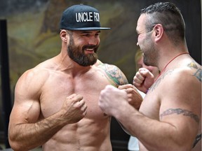 Former Edmonton Eskimos player Adam Braidwood, left, faces off with opponent Tim Hague after he weighs in at 250.1 lb. on June 15, 2017, at the Chateau Lacombe for his upcoming boxing match Friday in Edmonton.