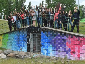 Once plagued with graffiti vandalism, Holy Trinity Catholic High School students, along with Edmonton police, partnered with Capital City Clean Up to paint a mural on the sides of the Mill Woods Park footbridge in Edmonton on June 28, 2017.
