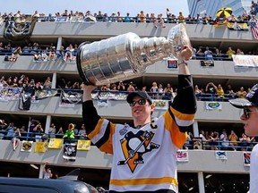 Pittsburgh Penguins&#039; Sidney Crosby hoists the Stanley Cup during the team&#039;s Stanley Cup NHL hockey victory parade on Wednesday, June 14, 2017, in Pittsburgh. (AP Photo/Gene J. Puskar)