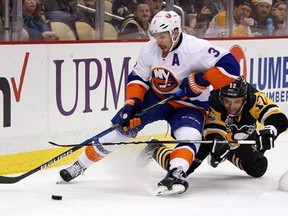 Pittsburgh Penguins&#039; Bryan Rust (17) collides with New York Islanders&#039; Travis Hamonic (3) during the second period of an NHL hockey game in Pittsburgh, Friday, March 24, 2017.Defenceman Hamonic was acquired by the Calgary Flames in a trade with the Islanders on Saturday. THE CANADIAN PRESS/AP/Gene J. Puskar