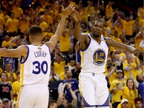 Stephen Curry #30 and Kevin Durant #35 of the Golden State Warriors react to a play against the Cleveland Cavaliers in Game 2 of the 2017 NBA Finals at ORACLE Arena on June 4, 2017 in Oakland, Calif.