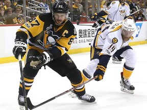 Sidney Crosby of the Pittsburgh Penguins, left, controls the puck against Mattias Ekholm of the Nashville Predators in Game 5 of the 2017 NHL Stanley Cup Final on June 8, 2017 in Pittsburgh.