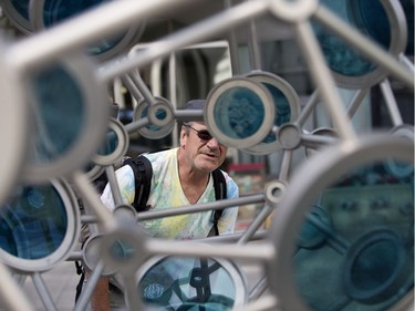 Brian Hicks looks at Transect, a new permanent public sculpture, created by Alberta glass artists Julia Reimer and Tyler Rock, installed along 108 Street north of 99 Avenue, in Edmonton, photographed on Thursday, June 22, 2017.