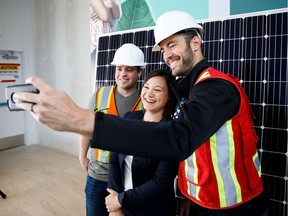 Alberta Environment Minister Shannon Phillips, centre, takes a selfie with Regan Miller, left, and Chris Sunderland, right, during a hard hat tour of the new Simons opening in Londonderry Mall later this summer in Edmonton, Alta., on Wednesday, June 21, 2017.