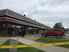 An Edmonton Police Service officer guards the 7-Eleven at 11868 145 Ave NW in Castle Downs Plaza beside glass shattered by gunfire on Sunday, June 11, 2017. Police responded to the gun complaint around 4:40 p.m. and found a man in life-threatening condition. The man later died in hospital. Catherine Griwkowsky/Postmedia