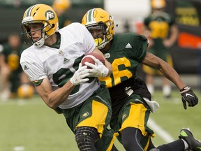 Chris Getzlaf (left) is chased after making a catch by Arjen Colquhoun (right) during Edmonton Eskimos training camp at Commonwealth Stadium in Edmonton on June 4, 2017.