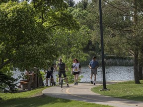 People enjoy the path along Beaumaris Lake, the largest and one of the oldest stormwater lakes in the Edmonton on June 6, 2017.