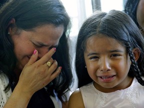 Yolanda Duarte Martinez (left) and her daughter Beverly Nicole Picon, 6, (right) break down in tears during a news conference in Edmonton on June 20, 2017. Yolanda, her husband Jilmar David Picon and oldest son Edisson Esmith Picon, 23, are being deported to Guatemala, where they fear for their lives. The other four children will return to the U.S., where they have citizenship, to live with a relative.