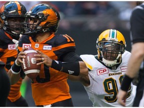 Edmonton Eskimos' Da'Quan Bowers, right, reaches to bring down B.C. Lions' quarterback Jonathon Jennings during the first half of a CFL football game in Vancouver, B.C., on Saturday, June 24, 2017.