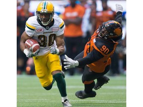 Edmonton Eskimos running back John White, left, gets away from B.C. Lions' Mic'hael Brooks during the first half of a CFL football game in Vancouver, B.C., on Saturday, June 24, 2017.
