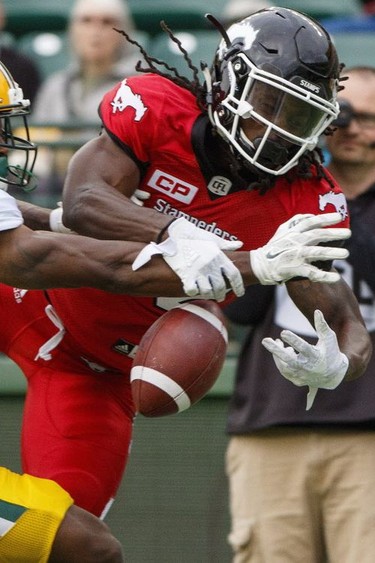 Calgary Stampeders Marken Michel (72) fumbles a touchdown pass under pressure from Edmonton Eskimos Mercy Maston (71) during second half CFL pre-season action in Edmonton, Alta., on Sunday June 11, 2017. The Stampeders won 36-35.