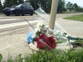 Flowers rest at the Suder Greens Dr. crosswalk  on Sunday, June 18, 2017 where a 57-year-old woman and her dog were killed crossing the street Saturday.