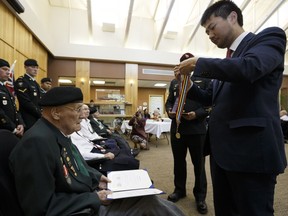 Kangjun Lee from the Consulate General of the Republic of Korea in Vancouver, presents Austin McClure (left) with an Ambassador For Peace Medal at the Kipnes Centre for Veterans in Edmonton on Thursday, June 1, 2017. Ian Kucerak / Postmedia