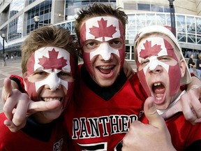 (LEFT-RIGHT) Kyle Hammond, Marc Maffey and Jamie Liddy yell for a photographer as they sell Canadian Flag face masks to raise money for charity before the Football game in Toronto, Monday, June 30, 2003.

CP INSTRUCTIONS DO NOT REMOVE ( NO SALES)
Toronto Sun Photo/David Lucas