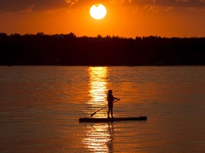 A stand up paddleboarder takes an evening paddle on Pigeon Lake. File photo.